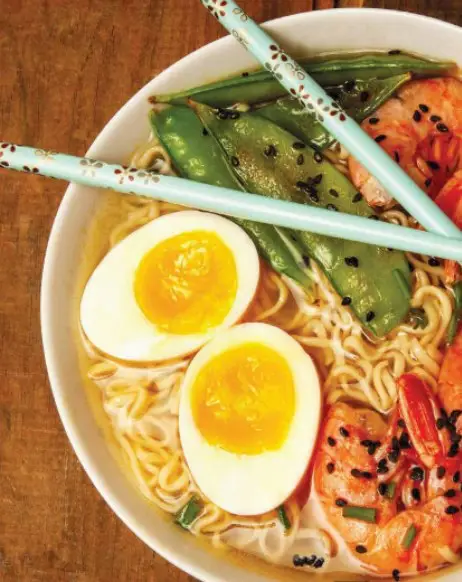 Ramen noodle bowl with eggs, shrimp and green vegetables